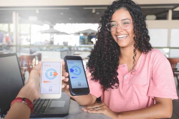Smiling woman showing a payment app on two phones