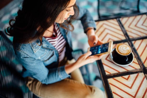 Student sending money from her phone at a cafe