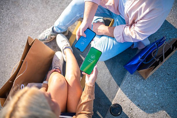 Two students with phones and shopping bags